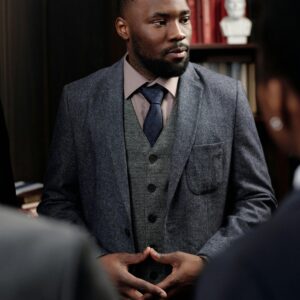 Confident businessman in a suit leading a discussion in a formal office setting.