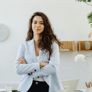 Professional woman with curly hair exuding leadership in a contemporary office environment.